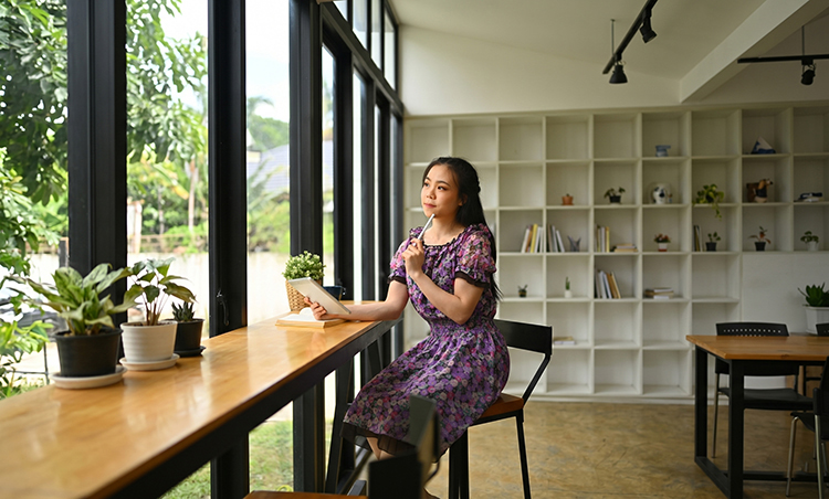 Professional woman looking out a window, representing CEO mindset, capacity, and intentional business growth